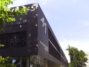 Campus Haupteingang mit Logo und Baum