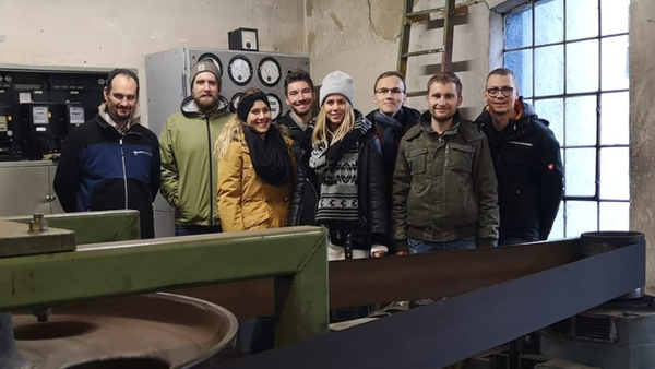 [Translate to English:] Gruppenfoto der Studierenden mit Professor in einem Wasserkraftwerk.